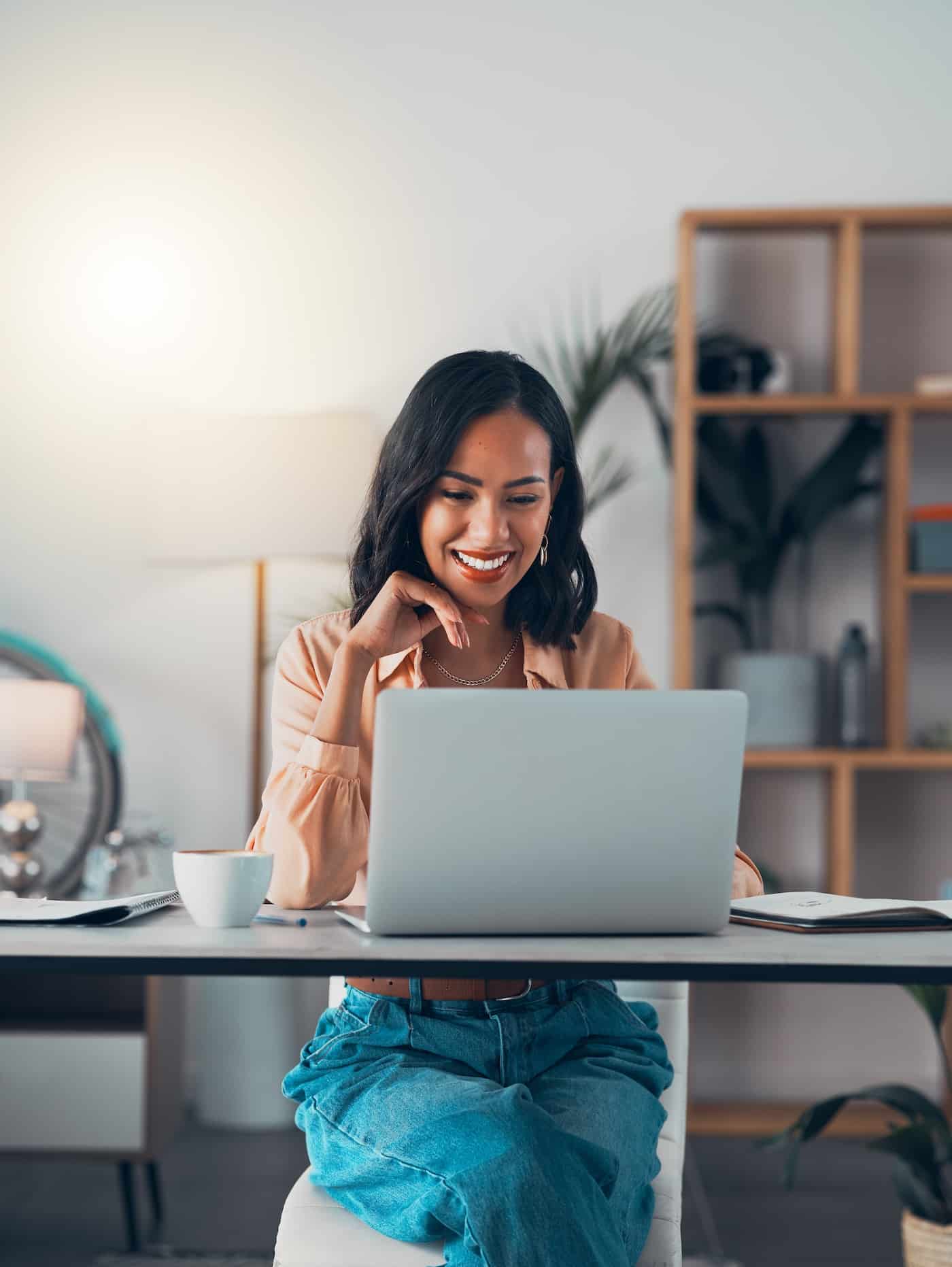 a woman sitting at a desk and using a laptop computer